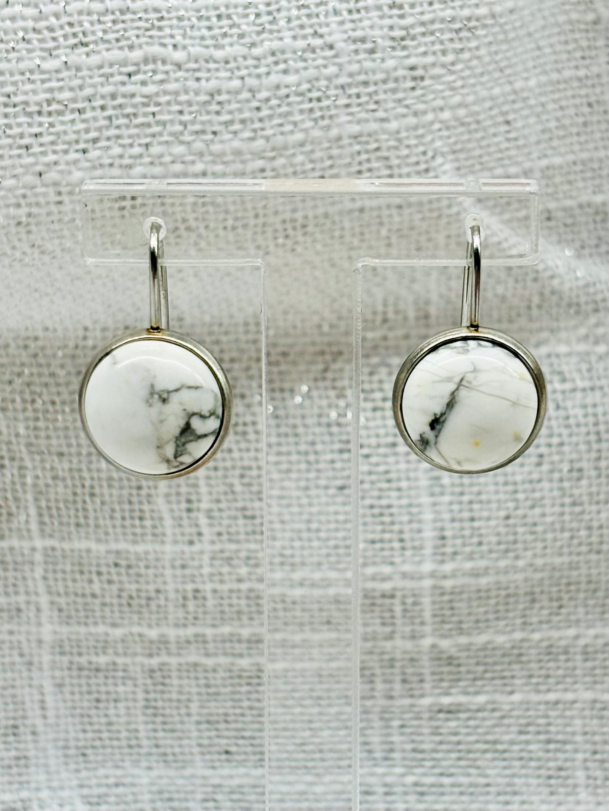 Boucles d'Oreille THÉANA, avec pierre d'howlite, exposées sur un fond en lin.