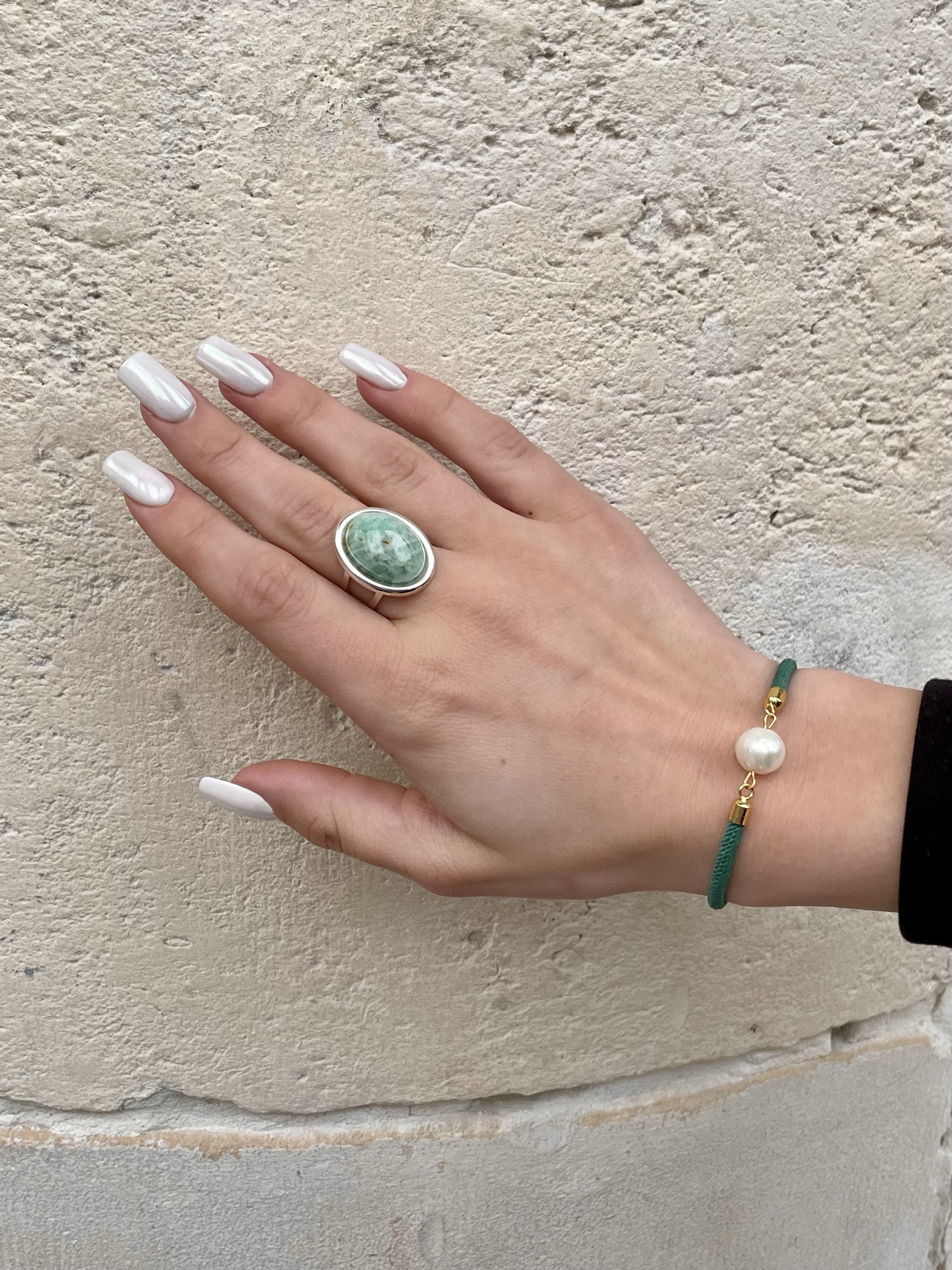 Bague THÉA, en argent et pierre d'Amazonite, portée sur une main de femme.