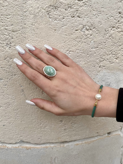 Bague THÉA, en argent et pierre d'Amazonite, portée sur une main de femme.