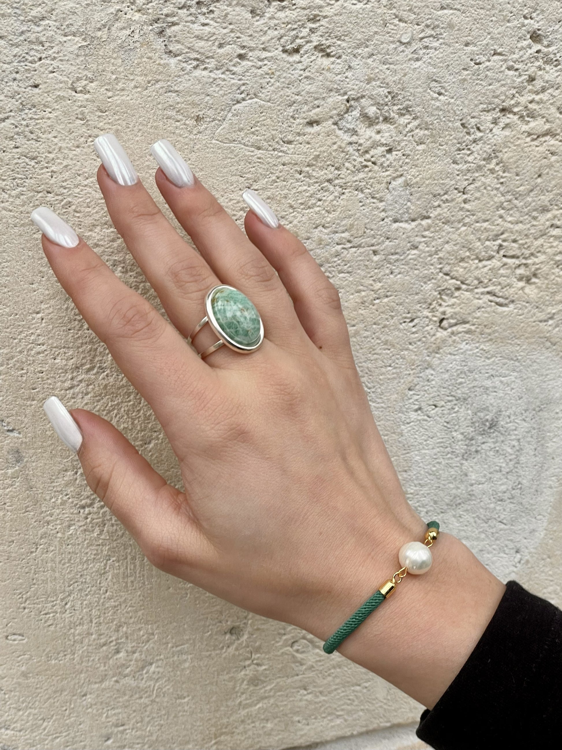 Bague THÉA, en argent et pierre d'Amazonite, portée sur une main de femme.