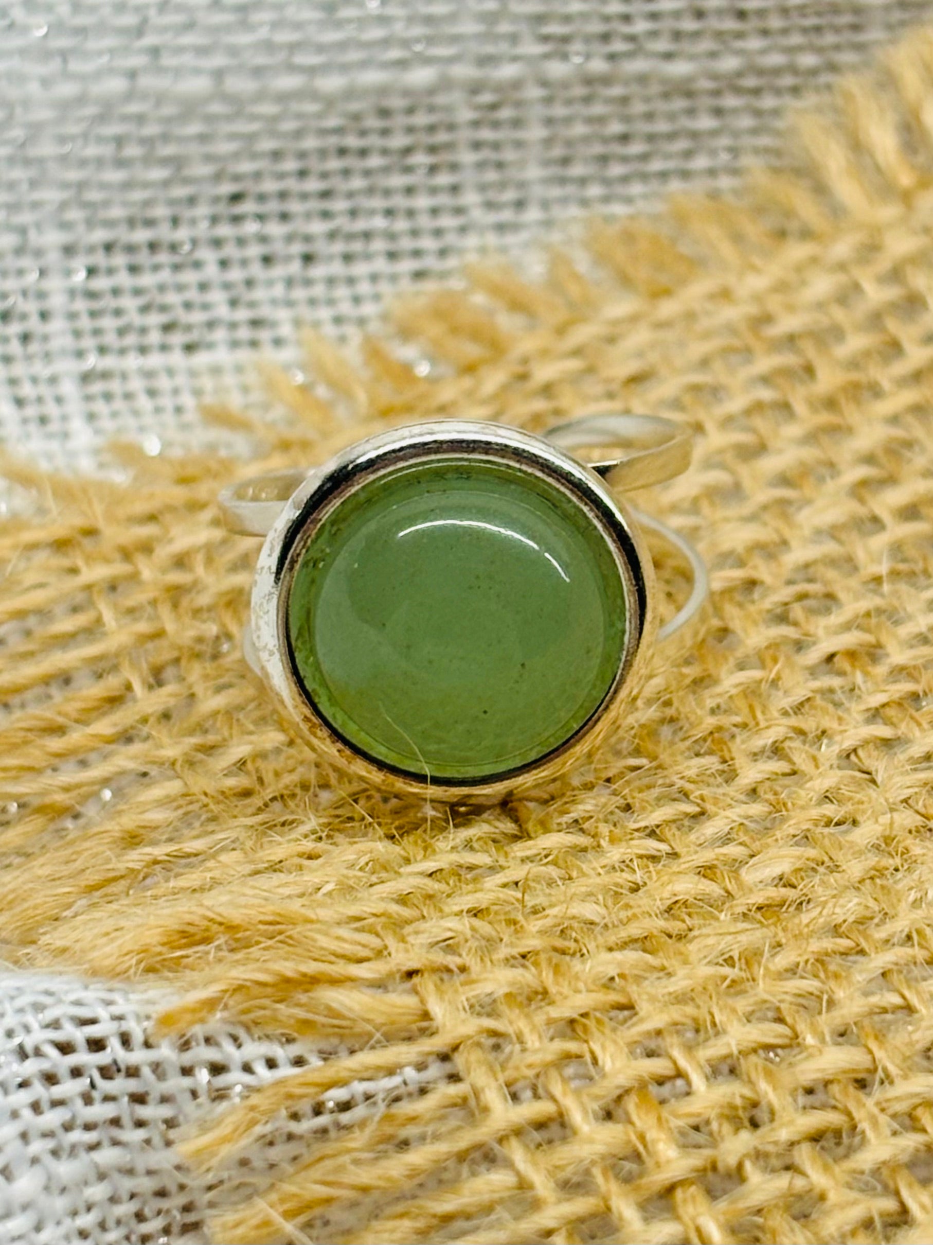 Bague THÉA, en argent et pierre d'Aventurine, sur un fond de lin et toile de jute.