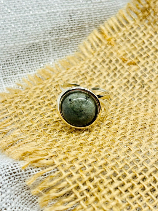 Bague THÉA, en argent et pierre de Labradorite, sur un fond de lin et toile de jute.