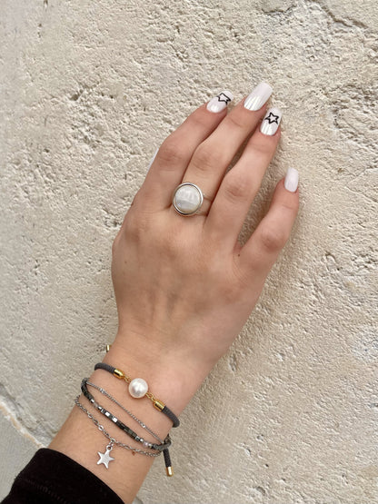 Bague THÉA, en argent et pierre de Lune, portée sur une main de femme.