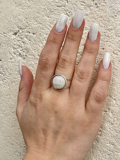 Bague THÉA, en argent et pierre de Lune, portée sur une main de femme.