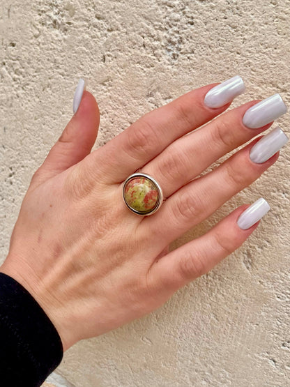 Bague THÉA, en argent et pierre d'Unakite, portée sur une main de femme.
