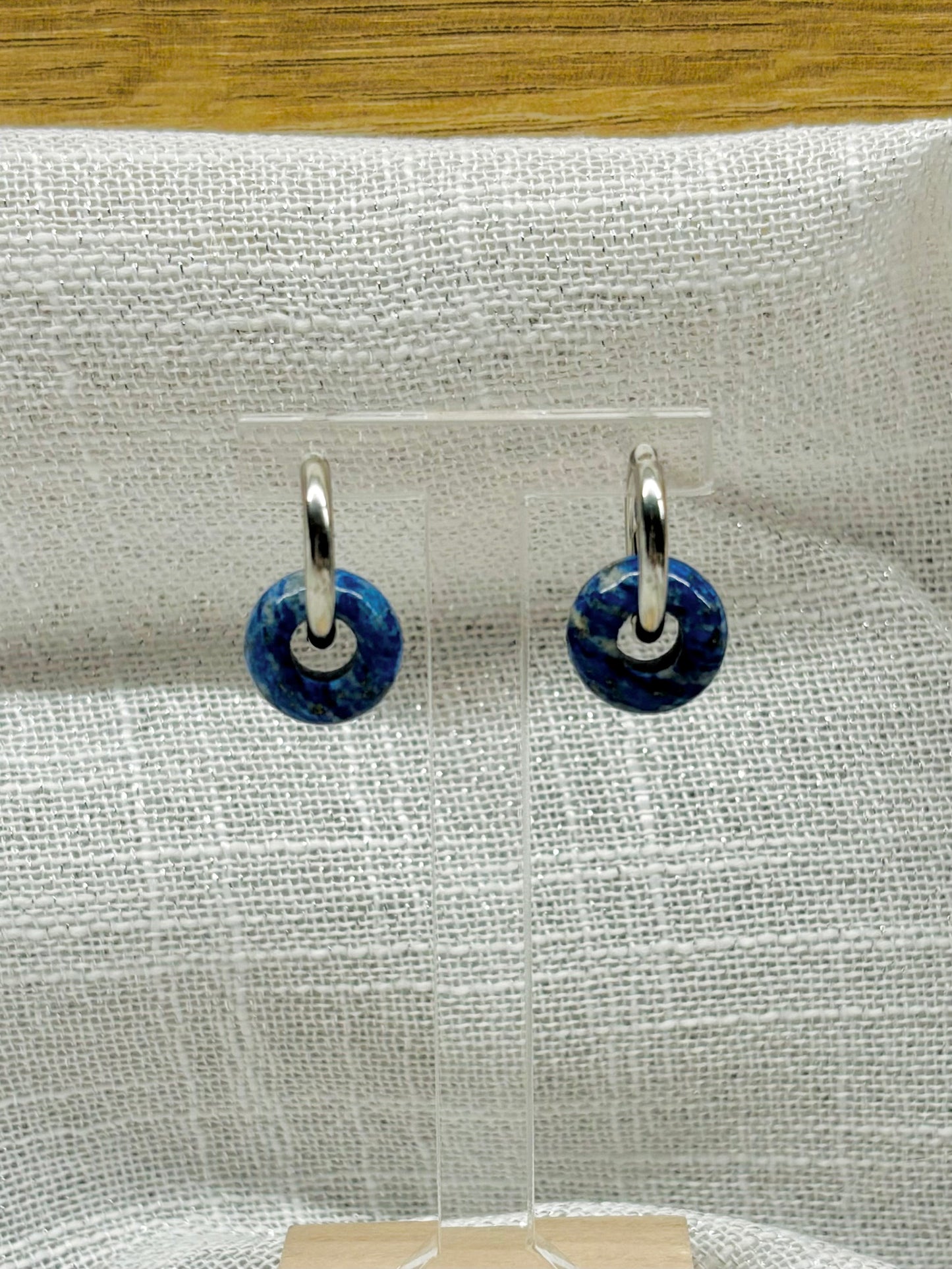 Boucles d'oreille THELMA, avec pierre de Lapis-Lazuli, exposées sur un fond en lin.