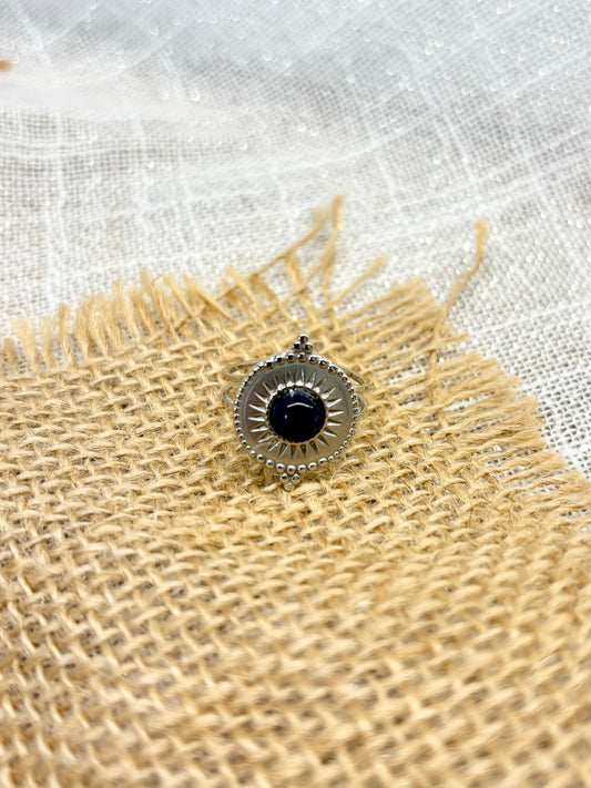 Bague ZÉLIE en acier inoxydable argent et pierre de Sodalite, exposé sur de la toile de jute et un fond en lin.