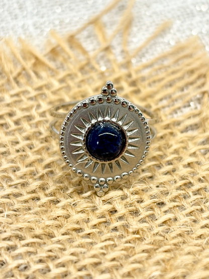 Bague ZÉLIE en acier inoxydable argent et pierre de Sodalite, exposé sur de la toile de jute et un fond en lin.
