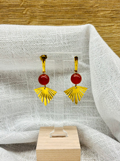 Paire de boucles d'oreille ZOA, en acier inoxydable doré et pierre de Cornaline, exposée sur un portant.